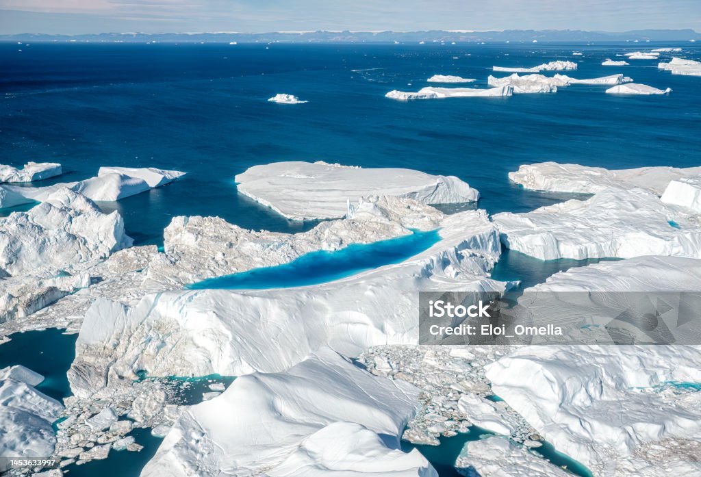Aerial view of icebergs on Arctic Ocean in Greenland.Disko bay Aerial view of a giant blue pool over and iceberg . Ilulissat Icefjord,  Arctic Ocean, Greenland. The picture has been taken from a plane Greenland Stock Photo