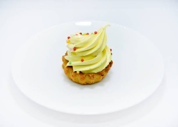 Delicious colorful cakes on a plate. Cream cakes on a white background. Shortbread cakes.