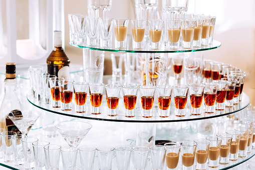 transparent tiered stand. many glasses with alcoholic beverages. wedding