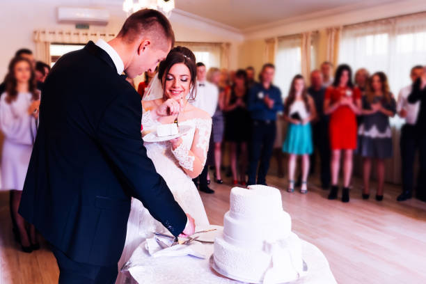 istock newlyweds is cutting their wedding cake. The bride is eating a w 1453634256