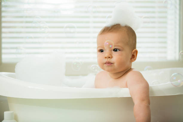 istock Cute little baby sitting in white bathtub 1453635202