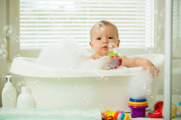 istock Cute little baby sitting in white bathtub 1453635280