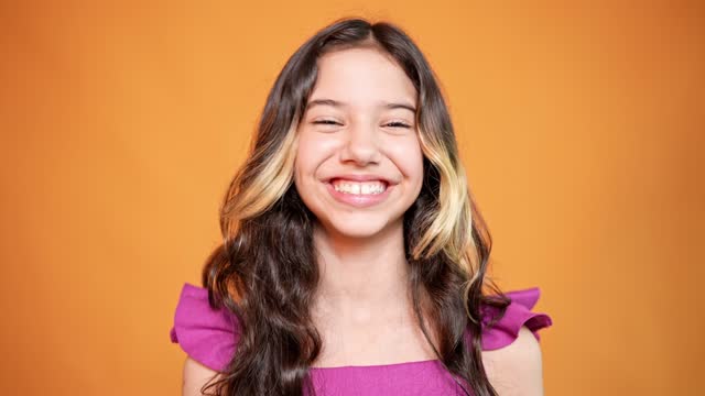 Portrait of a teenage girl on an orange background