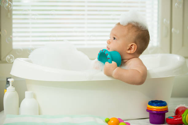 istock Cute little baby sitting in white bathtub 1453635529