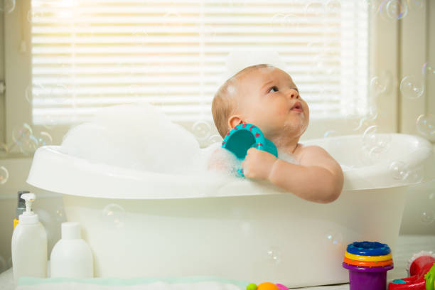 istock Cute little baby sitting in white bathtub 1453635531