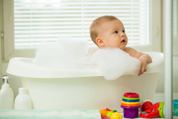 istock Cute little baby sitting in white bathtub 1453636268
