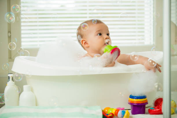 istock Cute little baby sitting in white bathtub 1453636384