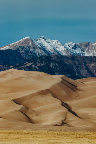 Great Sand Dunes National Park in Colorado with snowy mountains in background.