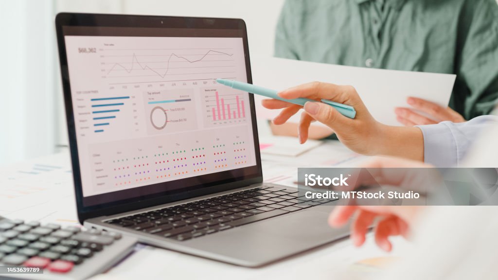 Closeup group of Asian business people meeting discuss project plan and financial results in office. Closeup group of Asian business people meeting discuss project plan and financial results in office. Marketing strategy analysis, stock market trading, financial consultant concept. Data Stock Photo