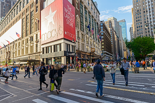 New York City, USA - May 20, 2014: Macy's Herald Square Store which is the flagship store for Macy's located on Herald Square in Manhattan, New York City. Pedestrians in crosswalk at busy midtown Manhattan shopping district of Herald Square. Image taken with a wide angle lens at sunset
