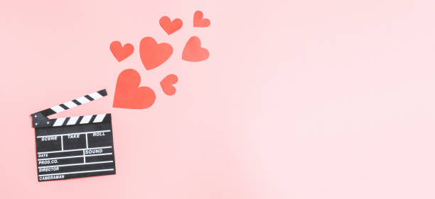 istock A clapperboard with paper red hearts lies on a pink background. 1453644528