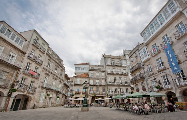 Vigo, Spain - June 4, 2011: Wide angle view  of Constitución square in old town Vigo, Pontevedra province, Galicia, Spain. People sitting in sidewalk cafes and residential buildings.