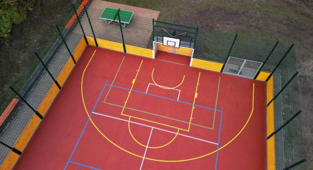 multifunctional outdoor playground for ball games at school. green artificial turf from a plastic carpet with lines. basketball hoops and soccer goals. around the grabbing high net and guardrails , multifunctional, guardrails, function, barriers parque infantil multifuncional al aire libre para juegos de pelota en la escuela. césped artificial verde de una alfombra de plástico con líneas. aros de baloncesto y porterías de fútbol. alrededor de la red alta de agarre y barandillas, tartán