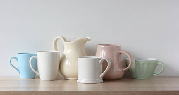 istock dishes on the shelf in a row, kitchen composition. glasses, jugs and a bowl. 1453647717