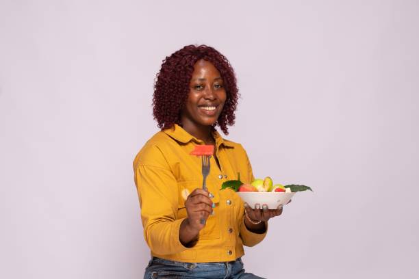istock an african lady with a bowl of fruit salad 1453648687
