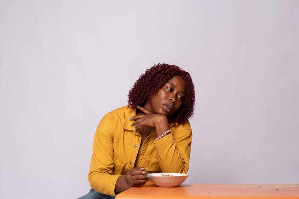 istock hungry lady holding an empty plate and looking unhappy 1453649602