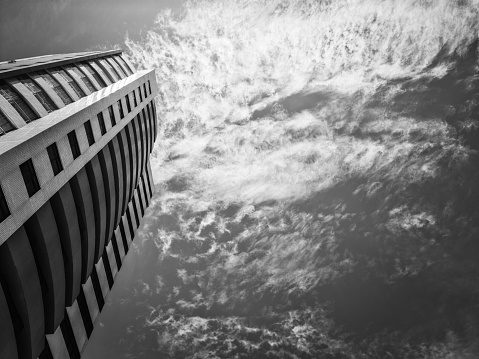 Architecture of a building. High building. Sky and clouds. Black and white photograph.