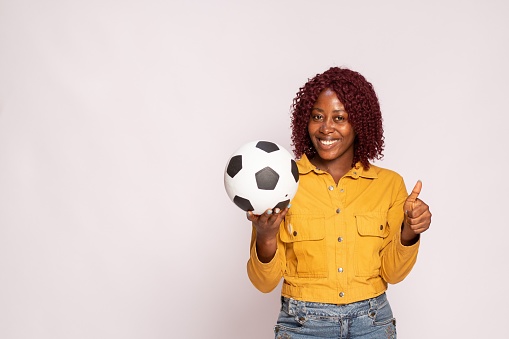 smiling black lady holding a football
