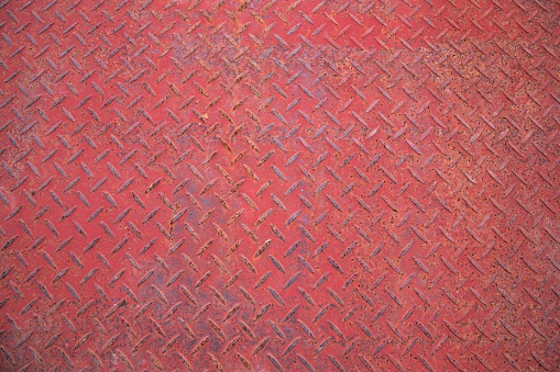 The view of a red-patterned metallic surface creates an uneven backdrop