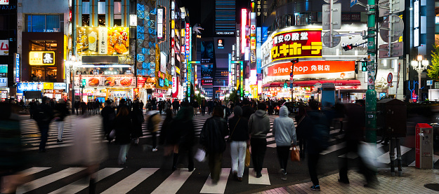 Night cityscape panoramic view, motion blurred of Japanese people, Asian traveler crossing road, car traffic transportation at Godzilla street Kabukicho district, Shinjuku Tokyo. Asia travel tourism or Japan transport concept