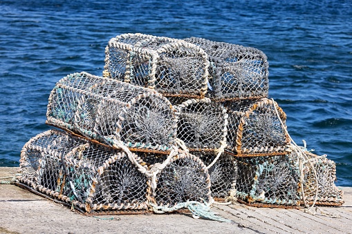 A pile of lobster pots on jetty into the sea