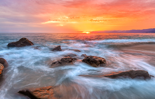 An Ocean Wave Is Breaking Against A Colorful Sunset Sky In High Resolution Image Format