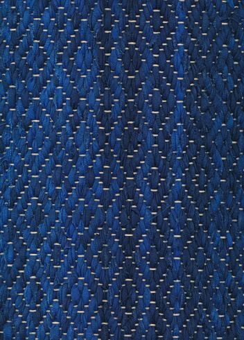 Closeup of dark handwoven rag rug in blue shades.