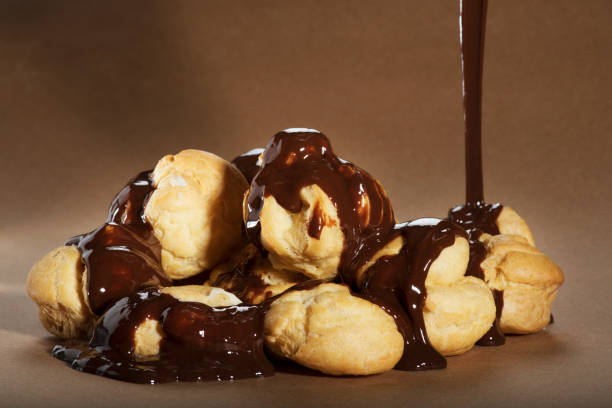 istock Pouring Chocolate on Delicious Profiteroles 1453658943