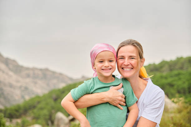 Portrait of a nurse with a child with cancer in nature stock photo