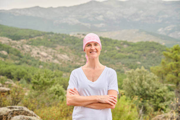 Woman with cancer with her arms crossed in nature stock photo