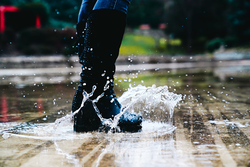 women boots jumping in puddles