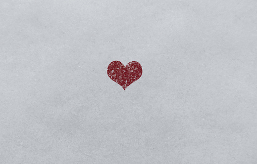 One red heart in snow ground with fresh snow on top. Happy Valentine's Day concept.