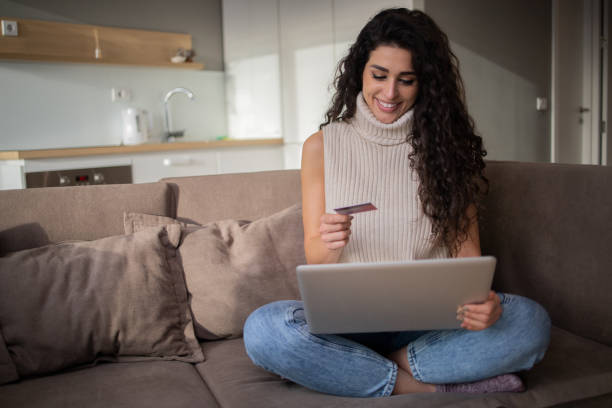 istock Woman using her credit card to shop online 1453662235