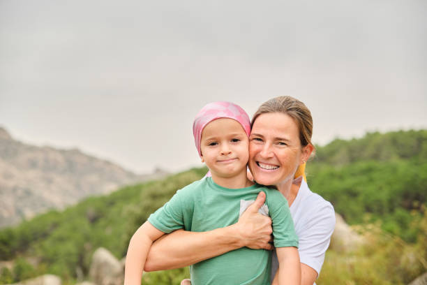 istock Mother hugging her son with cancer in nature. 1453662367