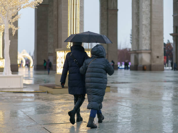 People walk in the Moscow public park VDNkH in the rainy winter day stock photo