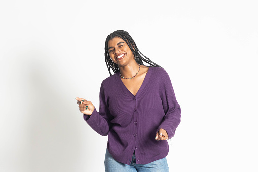 A beautiful African American woman strikes various poses in a studio.  She is wearing a purple shirt and appears to be dancing.
