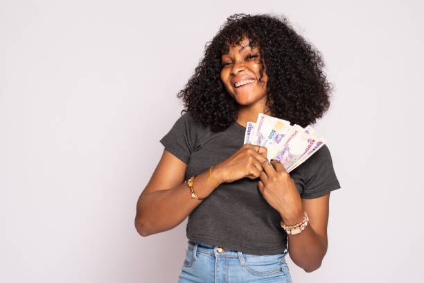 istock beautiful young african lady holding some cash 1453665319