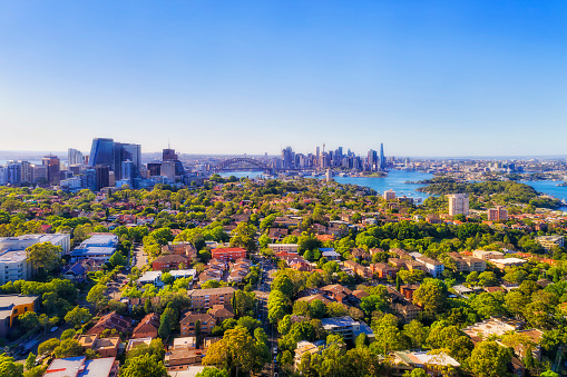 Wealthy leafy Lower North Shore suburbs of Sydney in aerial cityscape view towards Harbour and City of Sydney CBD.