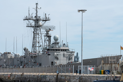 A Navy ship is docked for repairs/maintenance.