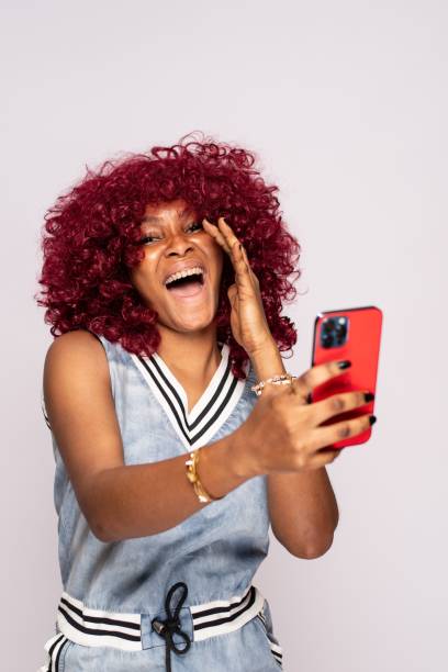 istock pretty african lady using her phone 1453666575