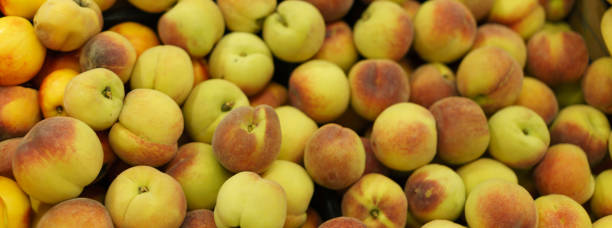 Fresh bright harvest of peaches in the shop.