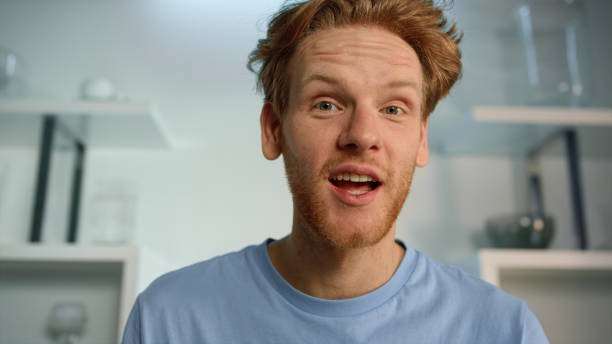 Excited man talking virtual meeting closeup. Impressed motivational speaker Excited man talking virtual meeting closeup. Impressed motivational speaker recording vlog at home. Smiling ginger guy manager support friend webcam view. Surprised student resting chatting online. slow motion face stock pictures, royalty-free photos & images