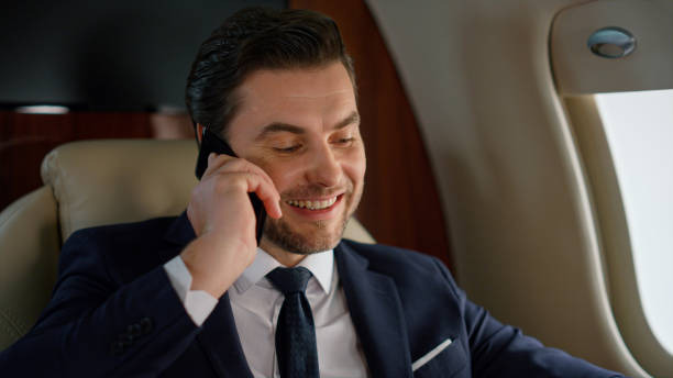 istock Portrait successful businessman calling partner on corporate airplane trip. 1453673452