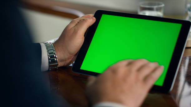 istock Closeup green tablet screen in luxury office. Man hand swiping mockup device 1453674107