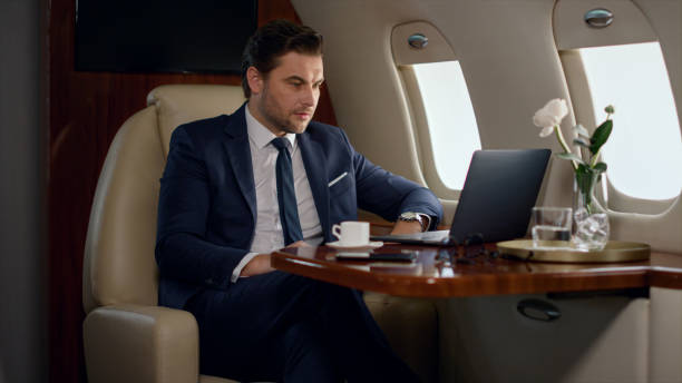 istock Serious businessman videocalling partner in private jet. Focused ceo talk online 1453675291