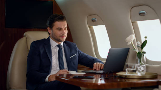 istock Focused businessman looking computer on corporate trip. Wealthy man work laptop 1453675382