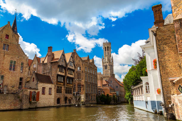 canal in bruges and belfry tower - belfort imagens e fotografias de stock