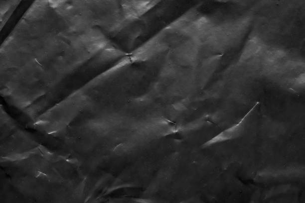 istock transparent plastic bag wrap overlay texture on black background 1453676922