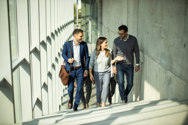 istock Small group of business people walking through hallway and talking 1453677194