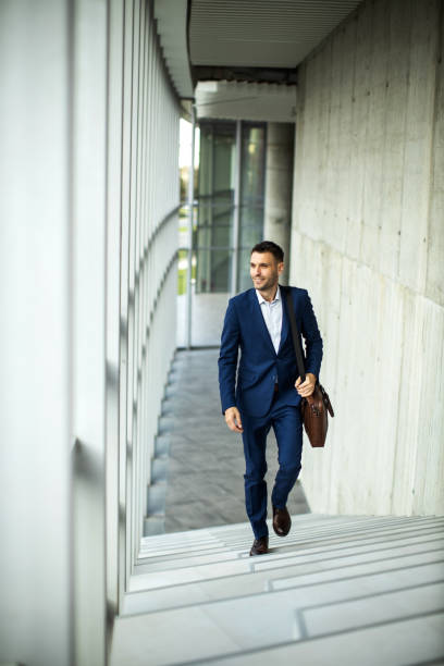 Jeune homme d’affaires marchant dans le couloir d’un bâtiment intérieur moderne et se rendant au bureau - Photo